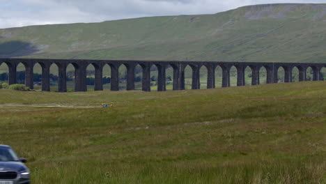 shot of the ribblehead viaduct from the east with car entering frame in foreground, carnforth