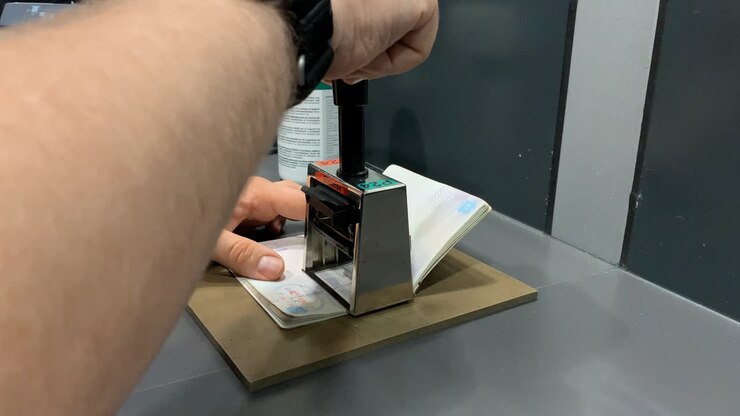 Funzionario che appone un timbro su un passaporto all'aeroporto, Controllo di frontiera