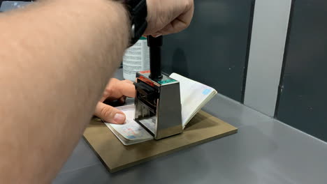 officer makes a stamp in a passport at the airport, border control.
