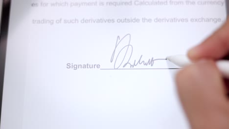 close up businessman hand working electronic signature on tablet by stylus. write business agreement of contract. man signing contract on tablet. business and technology concept.