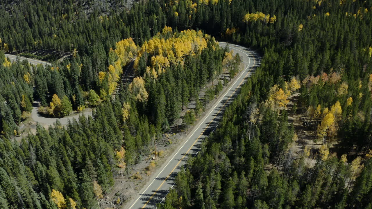 vista aérea panorámica hasta los coches en la carretera forestal de montaña con colores de otoño, 4k