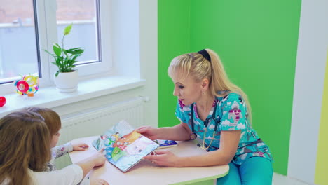 little girl at pediatrician office. friendly happy doctor pediatrician with patient child girl
