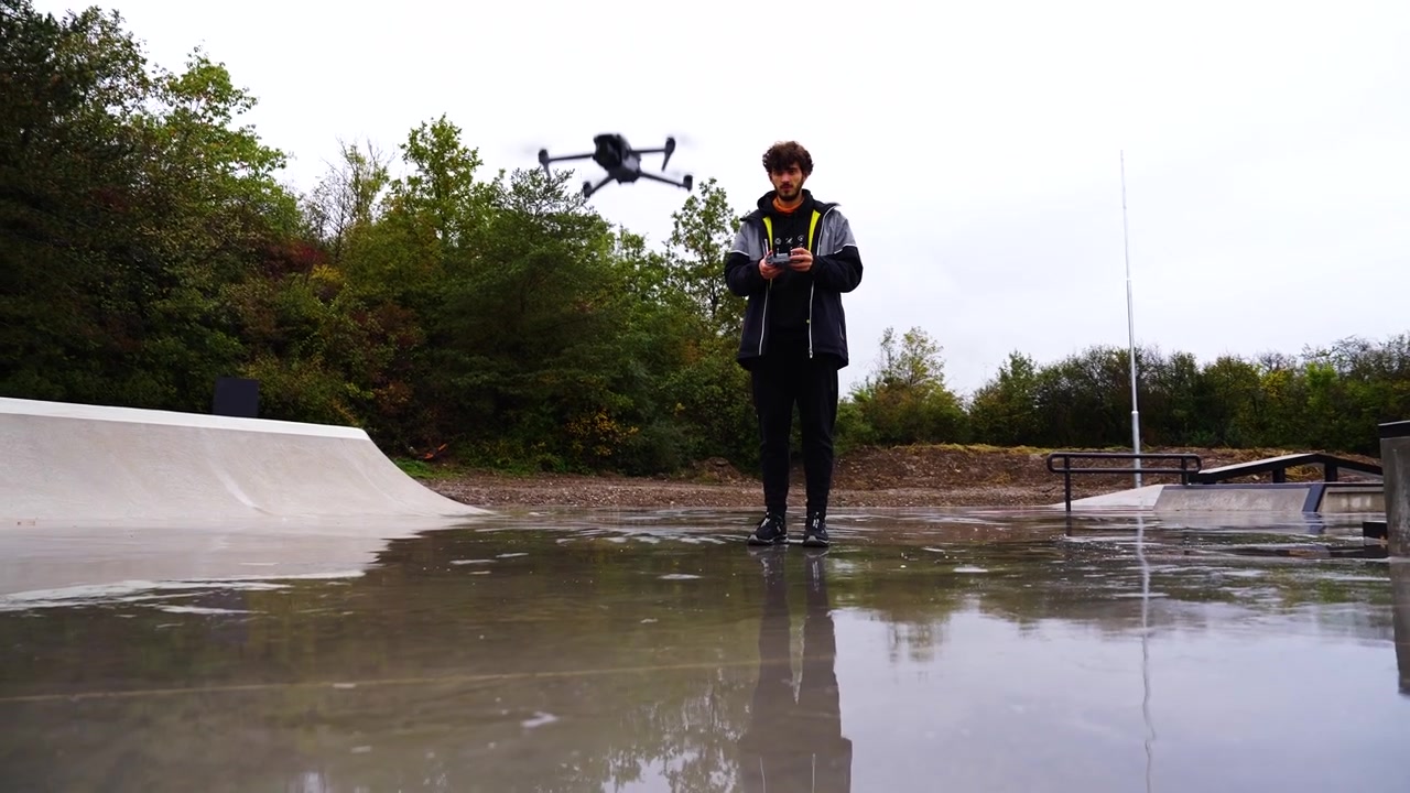 Drone pilot perform take off maneuver from wet skatepark ground, Czechia