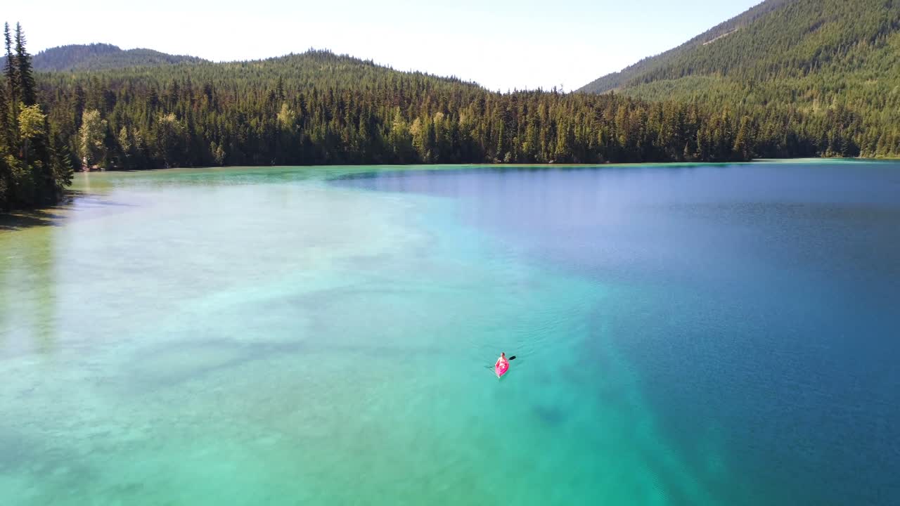 호수 4k에서 카야크를 타고 있는 여성의 공중 전망