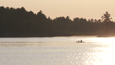 Kayakistas-Para-Remar-Por-La-Noche-En-El-Lago-Durante-La-Puesta-De-Sol