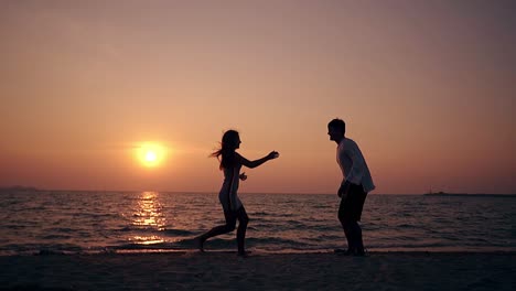 silhouette of girl running to man on sea beach slow motion