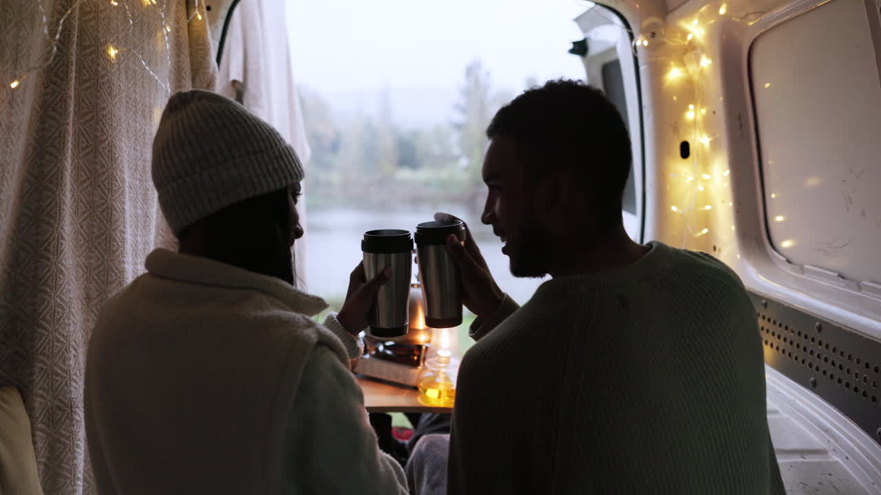 Coppia, brindisi e caffè in campeggio con caravan