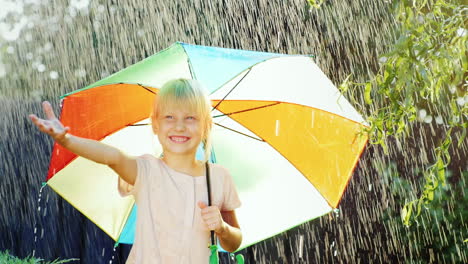 Alegre-Chica-Rubia-Disfruta-De-La-Lluvia-5-Años-Escondiéndose-Bajo-Un-Paraguas-Colorido