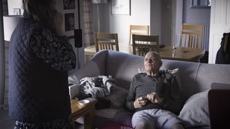 elderly man in living room talking to a woman