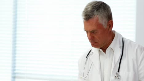male doctor using digital tablet while measuring height of girl