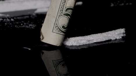 esnifar línea de cocaína con un billete enrollado, aislado sobre fondo negro liso
