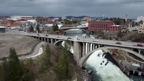 cars crossing over spokane river through monroe street bridge in washington - aerial, slow motion