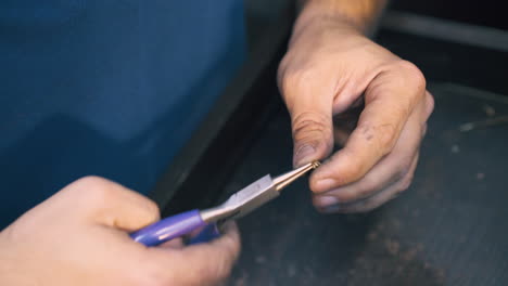 Juwelier-Verbindet-Ringe-Aus-Goldkette-Am-Tisch-In-Nahaufnahme