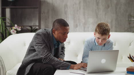 english teacher shows educative materials on laptop to boy