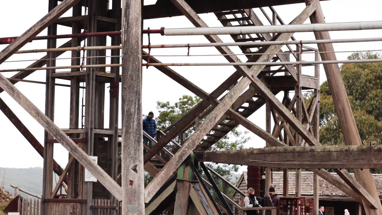 뒷면 에 나무 가 있는 나무 프레임 워크 에 올라가는 사람 들