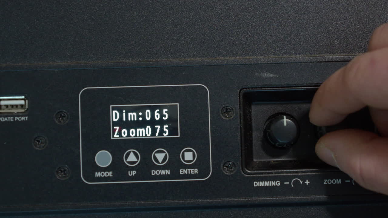 오른손은 무대 조명 제어 장치의 설정을 스크롤합니다.