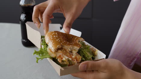 person eating a burger and soda