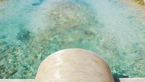 salt water flowing out of the tunnel to the salt flats in bonaire, kralendijk - tilt-up pan shot