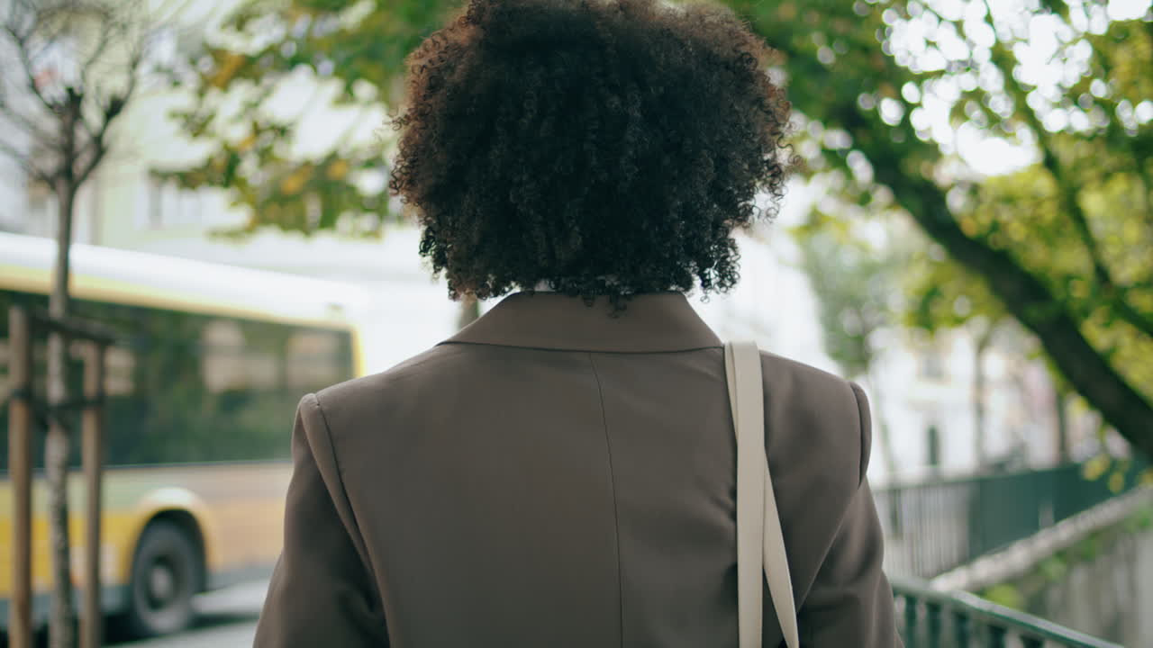 Girl walking city street looking back close up. African american woman relaxing.