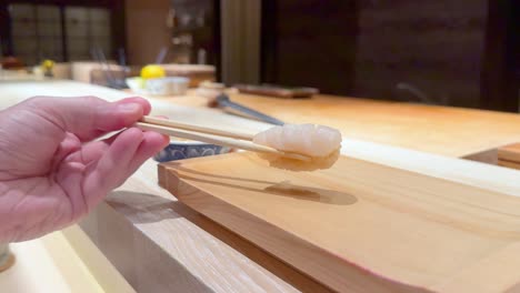 palillos para comer recogiendo sushi en un restaurante japonés