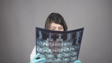 joven enfermera revisando rayos x aislados en fondo blanco. concepto de atención médica. filmado en 4k