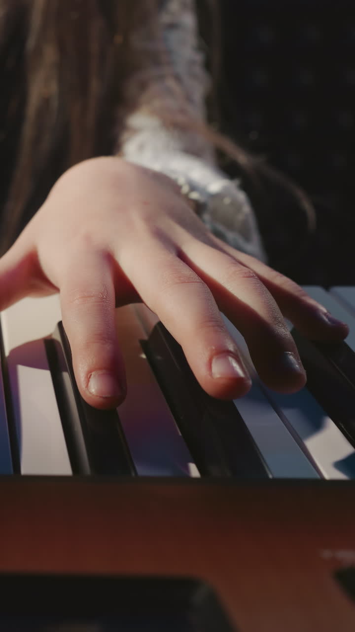 niño toca sintetizador en una escuela de música de cerca. niña pequeña presiona las teclas de instrumentos digitales con los dedos en un estudio de grabación de sonido. arte musical