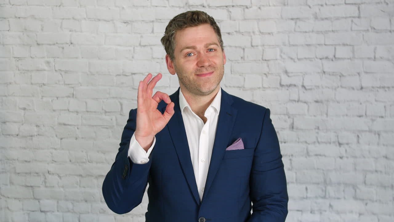 un hombre de negocios gesticulando bien con los dedos en una oficina