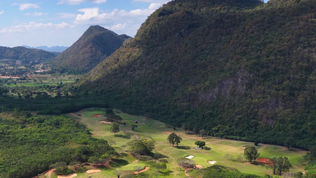 Il filmato realizzato con un drone cattura un campo da golf panoramico circondato da fitte foreste e montagne calcaree