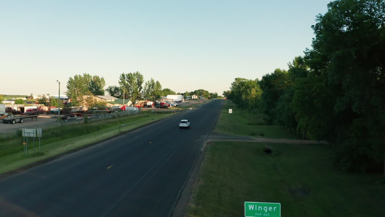 Aerial View of White SUV Driving Past 'Winger' Sign in Small Minnesota Town