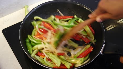 stir-frying peppers and onions