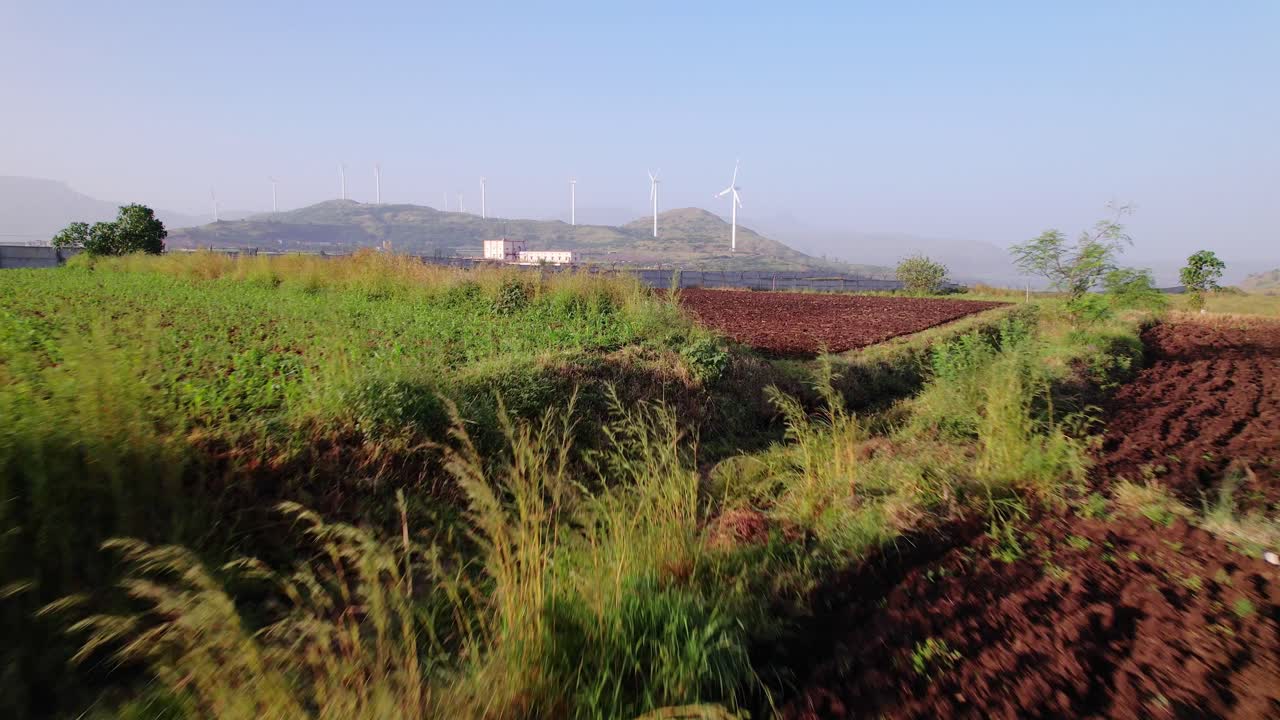 Closeup of agricultural fields reveals Mumbai Nagpur Expressway through wind farms, green corridor, Maharashtra, Drone shot