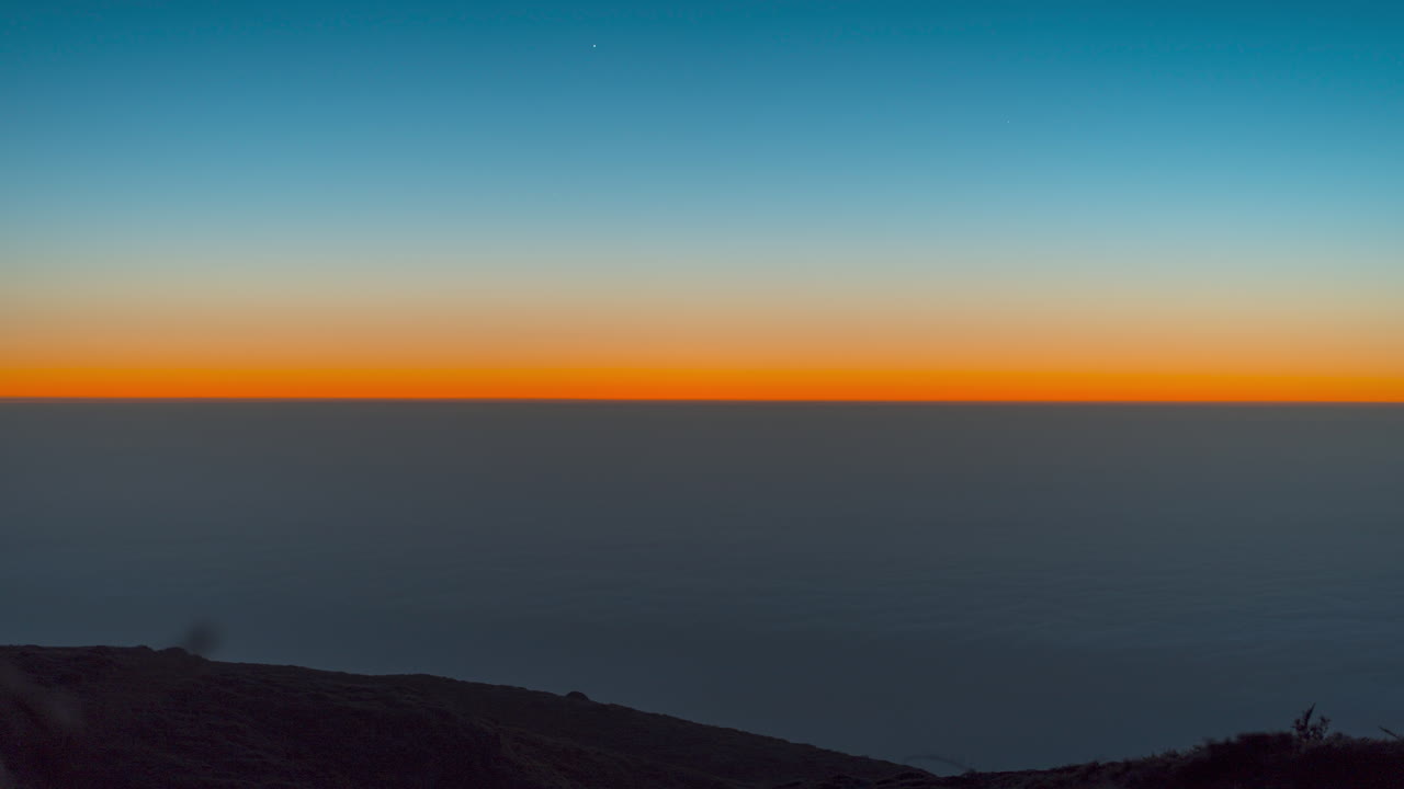 Sunset over Roque de los Muchachos, beautiful sky blending warm colors on the horizon, timelapse