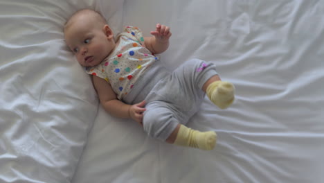 active baby girl on bed at home