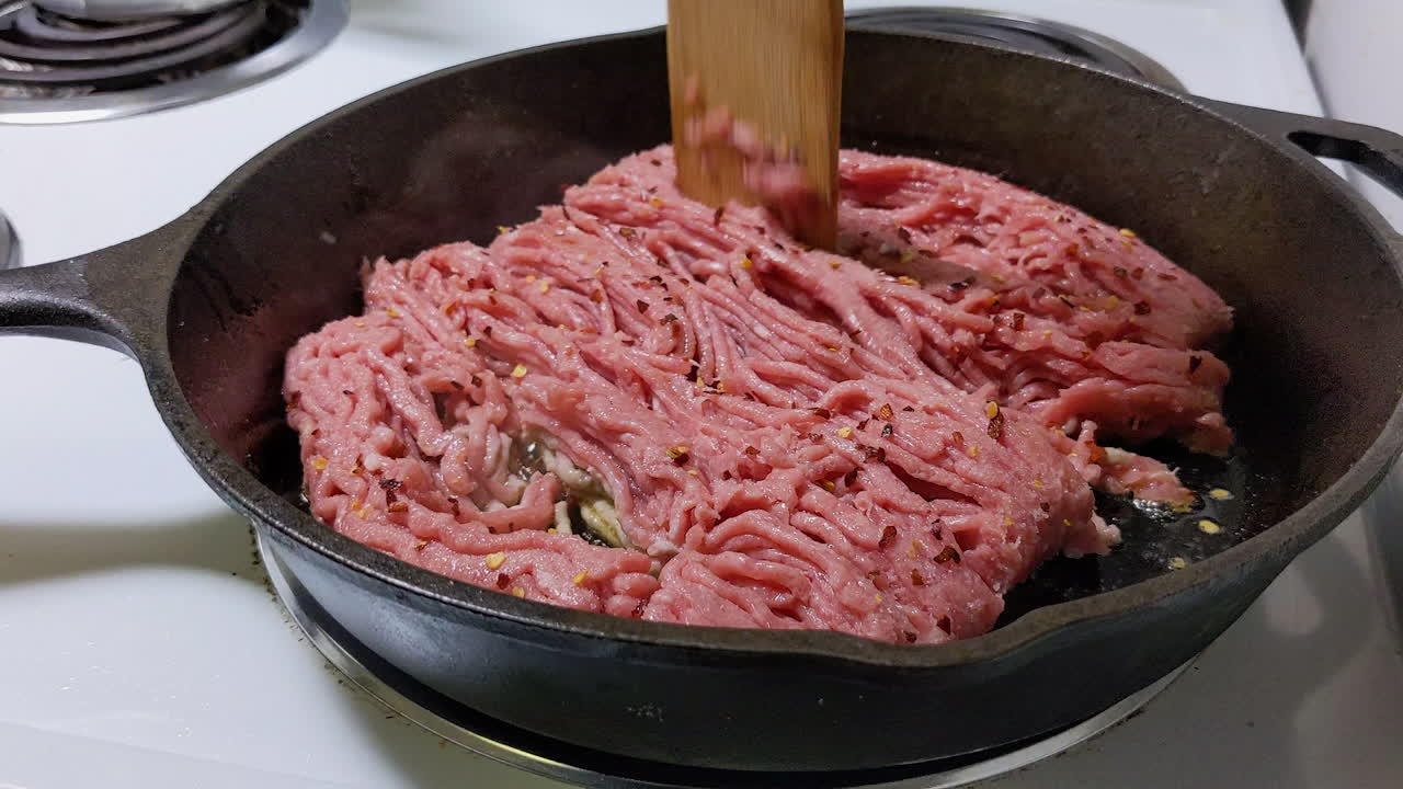 Frying ground beef on a cast iron skillet.