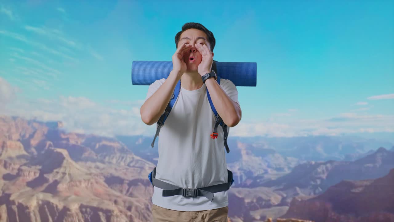 Asian Male Hiker With Mountaineering Backpack Screaming Holding Hands Near His Mouth While Traveling At The Top Of Mountain