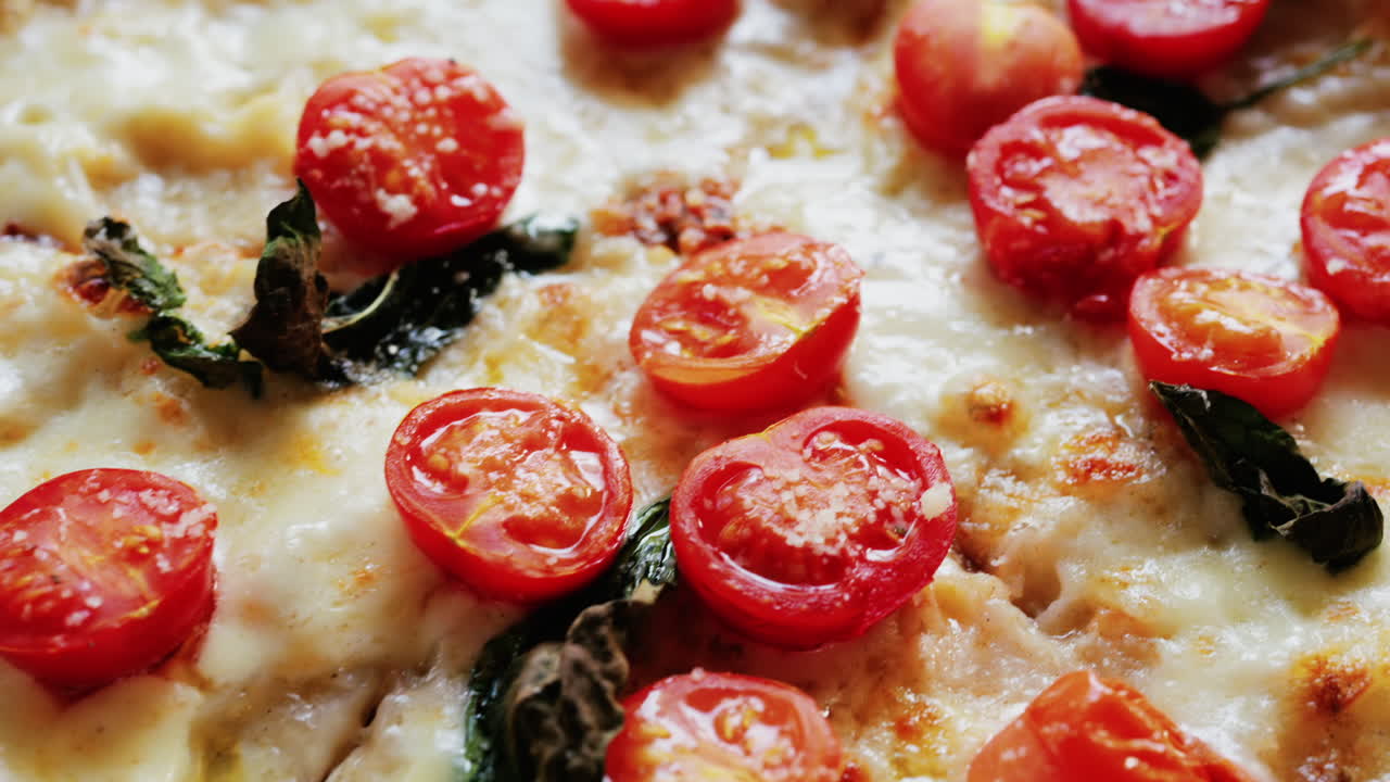 Close up of a classic margherita pizza with cherry tomatoes and basil