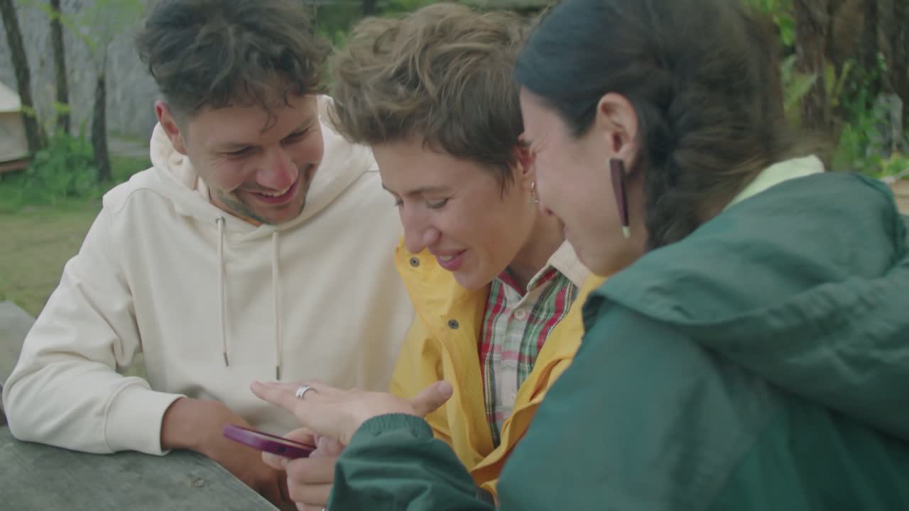 Young Friends Using Smartphone and Having Fun while Glamping