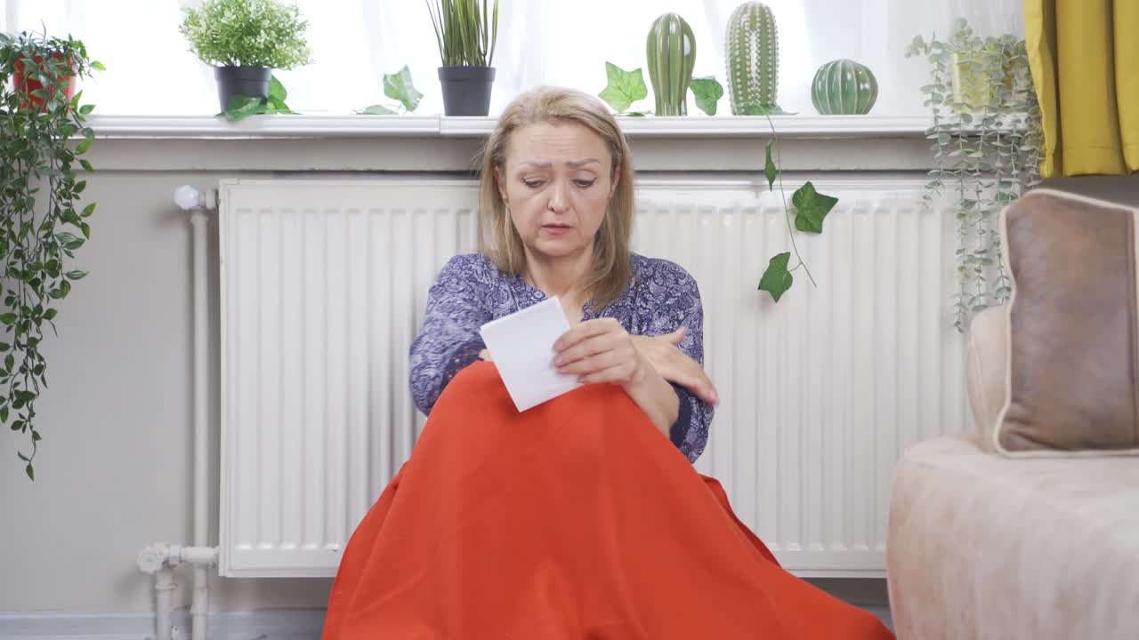 높은 가스 요금을 바라보는 여자는 차갑습니다.