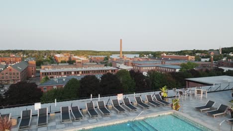 rooftop pool at sunset in biddeford, maine overlooking historic mill buildings and the saco river—urban charm meets relaxed luxury.