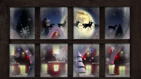 wooden window frame against snowflakes falling over multiple houses and trees on winter landscape