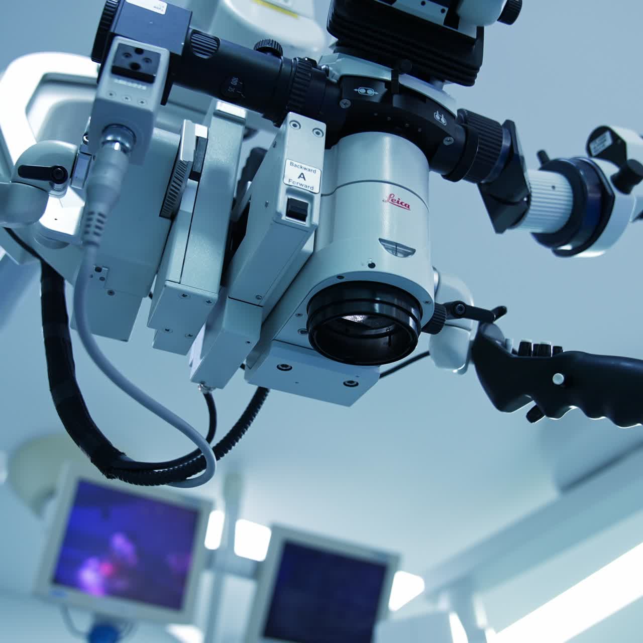New advanced equipment with microscope and powerful lens in modern surgery room. View from below. Blurred background