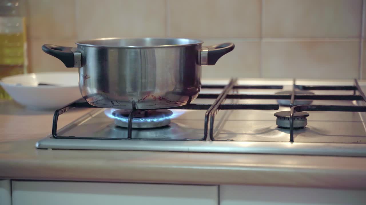 남자는 부엌에서 요리하는 가스레인지에 불을 붙인다
