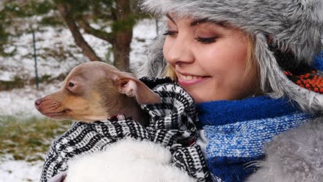 woman playing with her little dog outside winter
