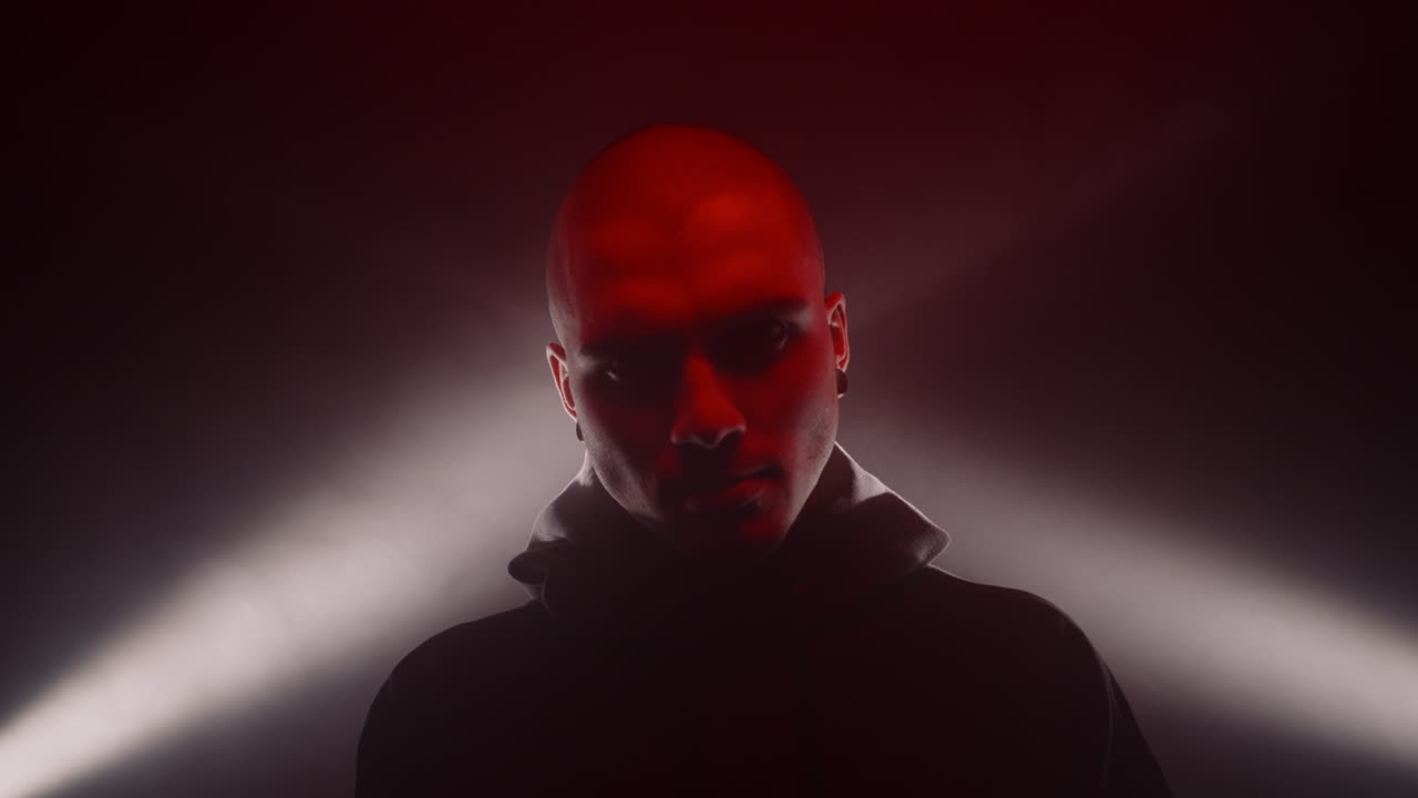 Bald Man in Hoodie with Dramatic Red and White Lighting