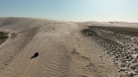recorrido en buggy en un paisaje con vastas dunas de arena - tiro de seguimiento aéreo