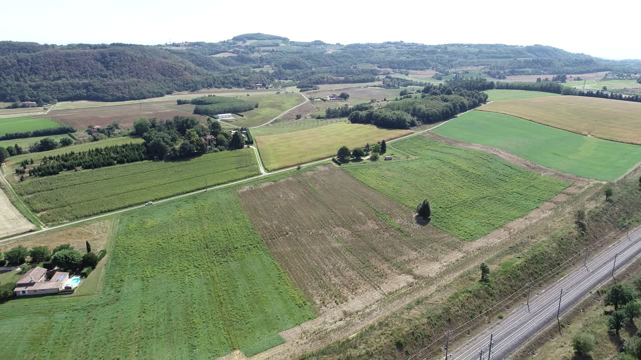 fotografía de un pueblo francés con granjas, vías de tren y casas