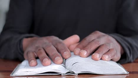 black man praying to god with bible in hands caribbean man praying with background with people stock video stock footage