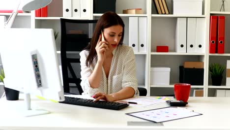 businesswoman sitting in office-chair talking on phone