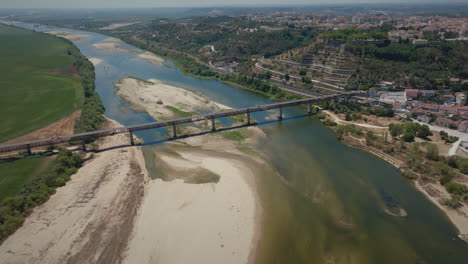 Dry-river-in-summer-over-a-bridge-long-aerial-shot