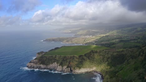 storm clouds casting shadow on azores coastline headlands, aerial